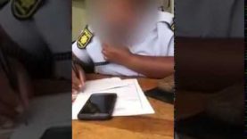 Polisievrou boer glo op foon terwyl mense wag